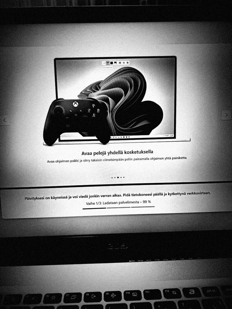 Windows 11 -päivitys käynnissä kannettavalla tietokoneella, Xbox-ohjain näkyvissä näytöllä.