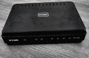 D-Link DSL-2680 -reititin pöydällä, vanha ADSL2+ modeemi edestä kuvattuna.